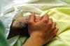 Older person's patient hand being held by nurse
