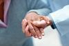 A health professionals hand steadying and elderly womans hand