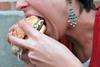 Woman stuffing a big burger into her mouth