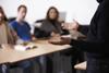 Lecturer talking to students seated at desks