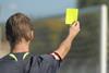 Referee holding up a yellow card