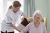 A care home working helping an elderly woman