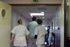 Hospital staff pushing trolley down corridor