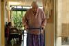 Elderly patient walking round corridors of nursing home