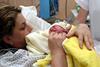 A woman in hospital holding a newborn baby