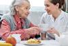 Older woman and younger woman, nurse, smiling at each other