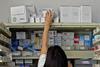 A pharmacist reaches for a prescription