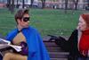 Superhero and older woman on a park bench