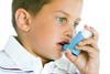 Young boy using an inhaler for treatment of asthma