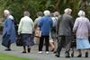 Elderly people walking in care home grounds