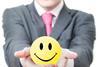 Man holds out smiley face stress ball