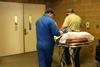 Two nurses pushing trolley into hospital