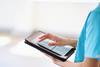 Medical Professional Using Tablet for Digital Health Records in Modern Hospital