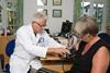 GP checks patient blood pressure