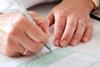 Woman's hands writing out a prescription