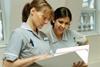 two student nurses looking at patient paperwork