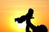 Silhouette of man and baby in sunset