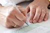 Woman's hands writing out a prescription