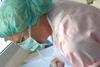 Midwife washing newborn baby