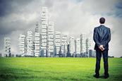 Businessman looking at city skyline which includes leadersip phrases such as "success"