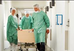 Patient on trolley being wheeled through corridor