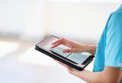 Medical Professional Using Tablet for Digital Health Records in Modern Hospital