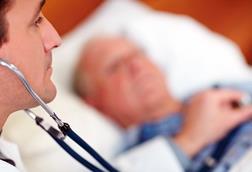 Old man in bed, doctor using stehoscope