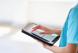 Medical Professional Using Tablet for Digital Health Records in Modern Hospital
