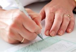 Woman's hands writing out a prescription