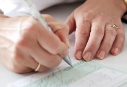Woman's hands writing out a prescription