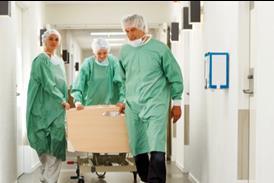 Patient on trolley being wheeled through corridor