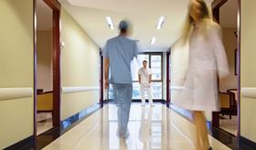 Blurred hospital corridor with three figures in it