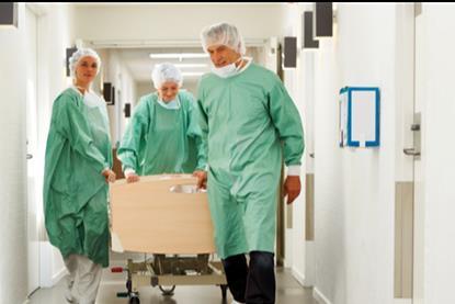Patient on trolley being wheeled through corridor