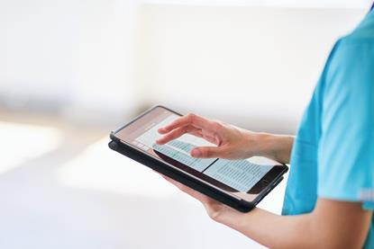 Medical Professional Using Tablet for Digital Health Records in Modern Hospital