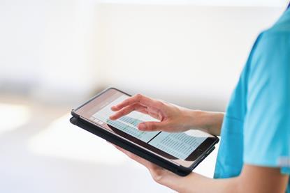 Medical Professional Using Tablet for Digital Health Records in Modern Hospital