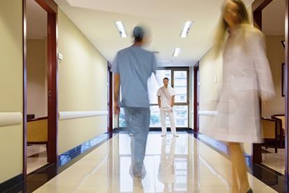 Blurred hospital corridor with three figures in it