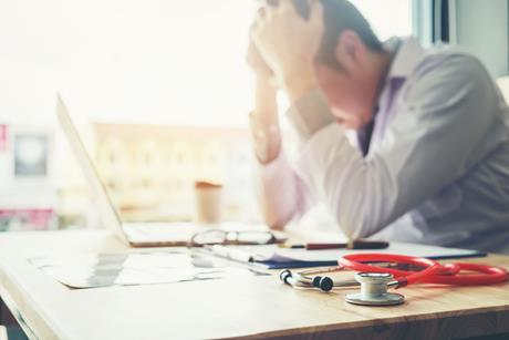 Stressed doctor with stethoscope