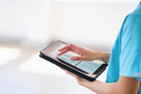 Medical Professional Using Tablet for Digital Health Records in Modern Hospital