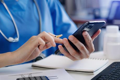 Medical technology concept. Doctor working with smartphone and stethoscope in office