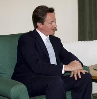 David Cameron sitting on a chair listening