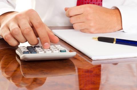 Businessman using calculator and spreadsheet for finance calculations