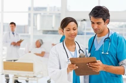 Male and female nurse talking discussing patient notes
