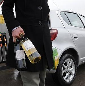 Man carrying two bottles of supermarket wine
