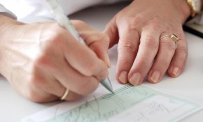 Woman's hands writing out a prescription