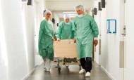 Patient on trolley being wheeled through corridor