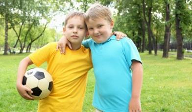 Two boys, hugging with football