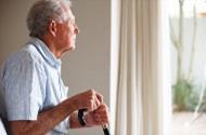 mental health Elderly man with a walking stick looking outside