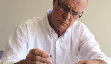 Man looking at pills with confused expression