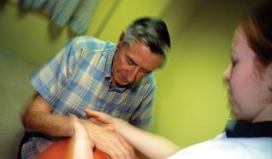 Man after a stroke having physiotherapy on his hands