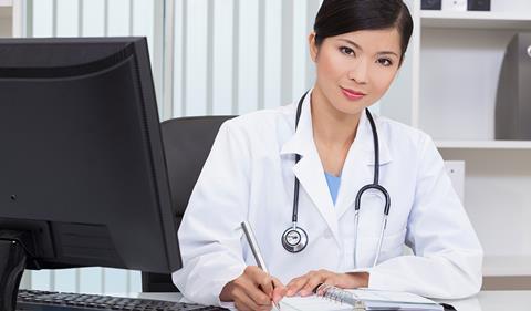 Woman doctor, sitting at desk